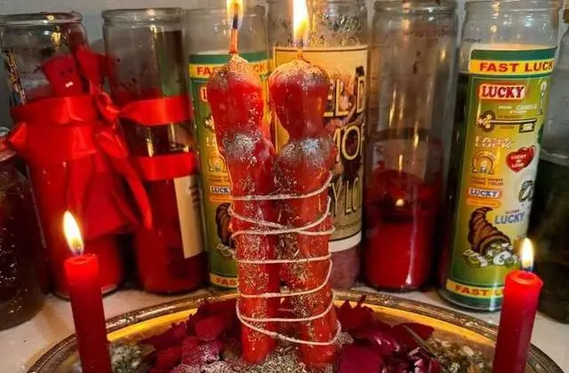 Get Back Your Lover in USA - Red couple candles bound with ribbon on a rose altar