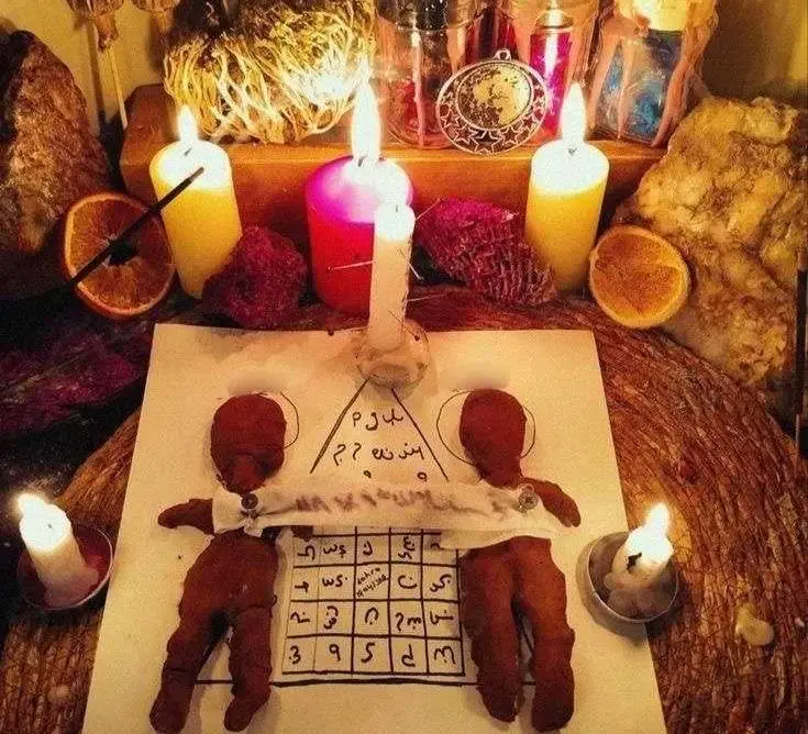 Hire the Best Love Spell Caster in USA - Candlelit altar with two cloth figures and a written talisman