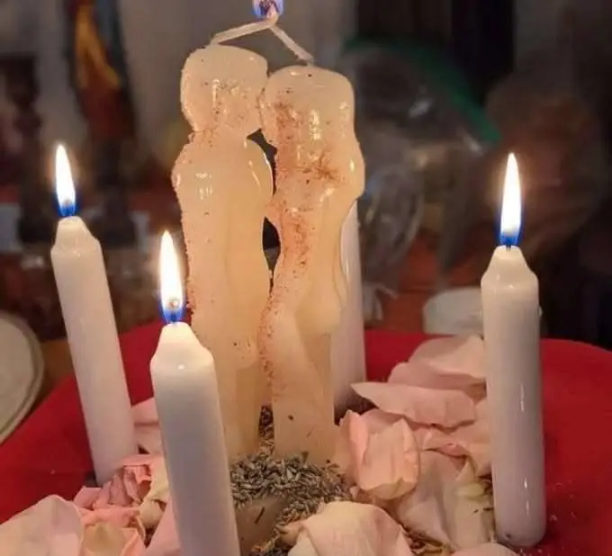 Marriage and Relationship Harmony in USA - White couple candle surrounded by white candles and rose petals