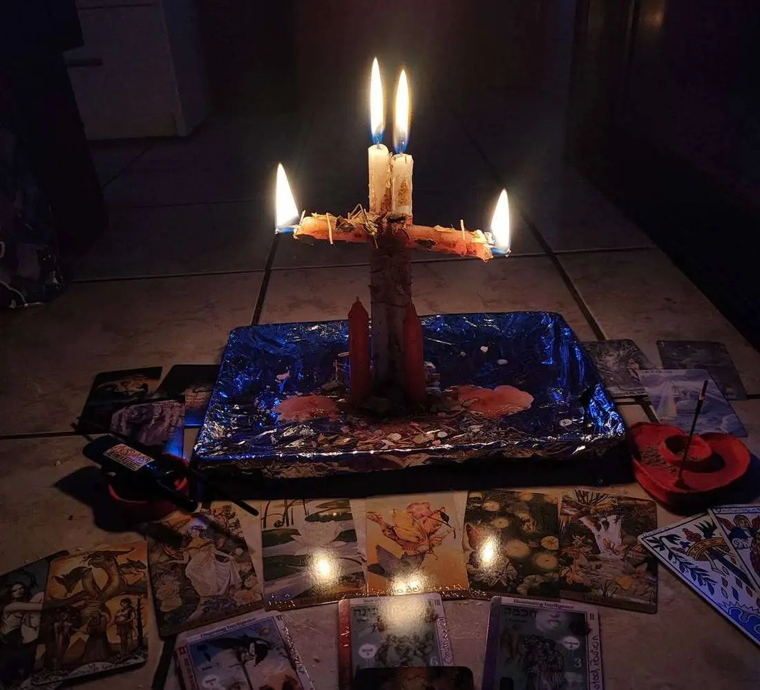 Numerology Reading in USA - Lit candles over a spread of reading cards at night