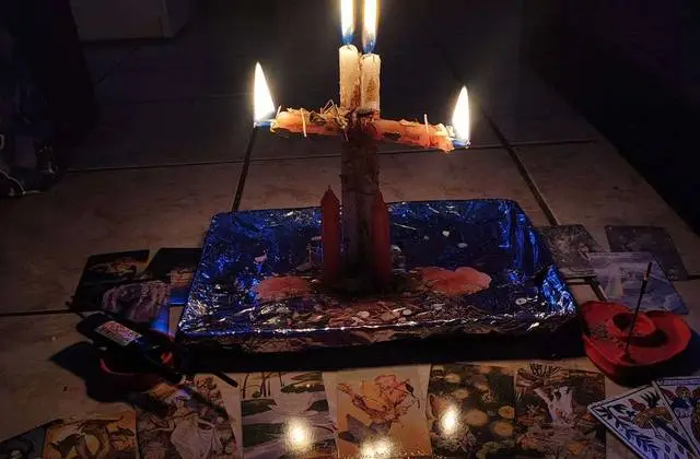 Numerology Reading in USA - Lit candles over a spread of reading cards at night